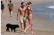 Charlize Theron plays with a male companion and her dogs on the beach in Malibu, CA