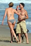 Charlize Theron plays with a male companion and her dogs on the beach in Malibu, CA